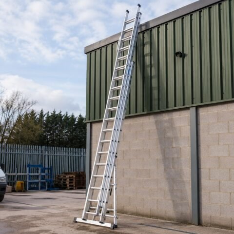 Trade aluminium triple extension ladder stored securely in a hire yard